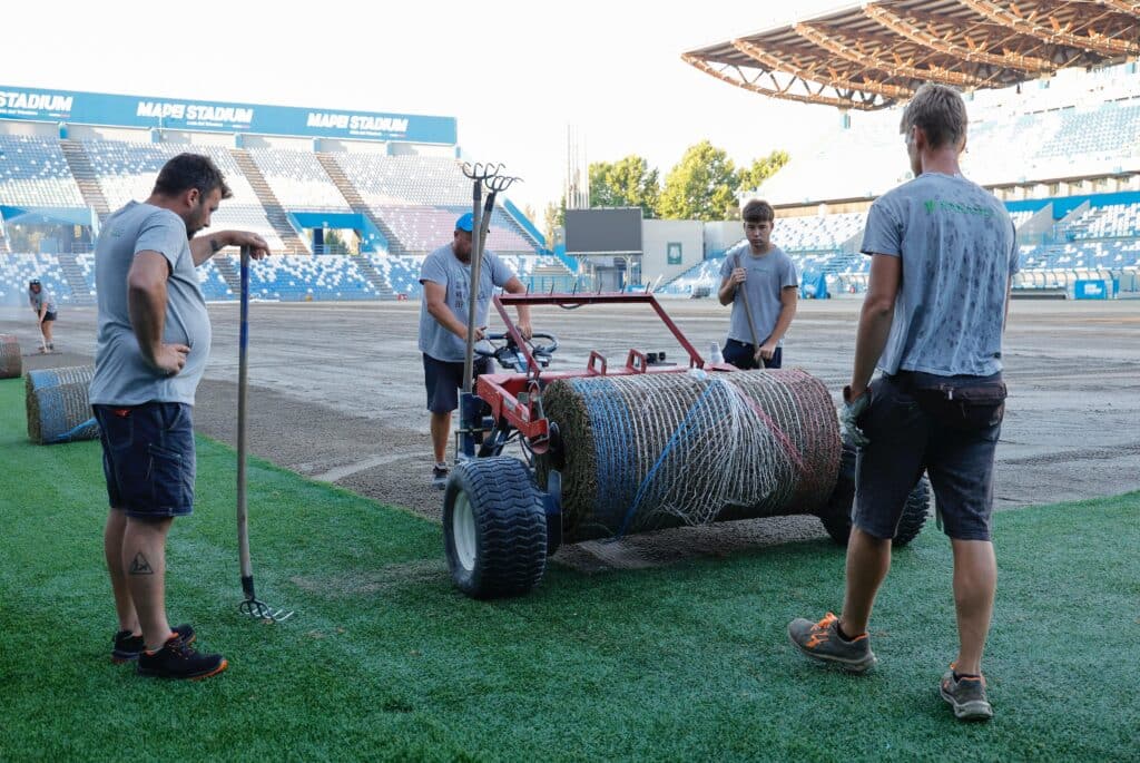 Rotoli di tappeto erboso pronti per la posa durante il rifacimento di uno stadio, Paradello