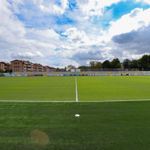 Campo da calcio con edifici dello stadio sullo sfondo, manutenzione Paradello