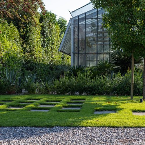 Giardino privato con pavimentazione a scacchiera nel prato, progetto Paradello sul Lago di Garda